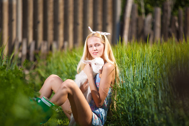 Beautiful country girl with a small goat in her hands - Foto, immagini