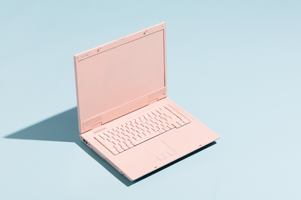 Retro roze laptop op een pastel blauwe achtergrond. Technologie. Creativiteit en minimalisme. - Foto, afbeelding
