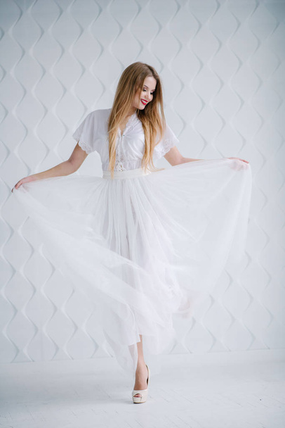 Beautiful young woman with make up  in white dress posing in studio - Zdjęcie, obraz