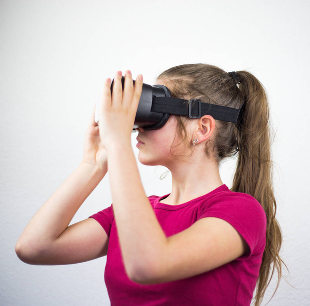 Adolescente con occhiali di realtà virtuale sulla testa, godendo guardando, tecnologia incredibile, sfondo bianco, studio
 - Foto, immagini