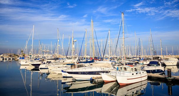 Marina em Larnaca hospeda barcos ancorados, Chipre. Reflexão de barcos, céu azul com fundo de nuvens
. - Foto, Imagem