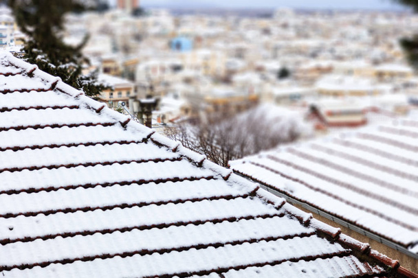Sneeuw bedekte daken. Winter, tijd voor vakantie in een stad in vorst. Vervagen de achtergrond, close-up, detail - Foto, afbeelding
