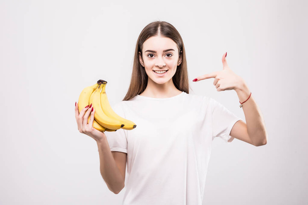 Young woman pointed on bananas isolated on white background - Foto, afbeelding