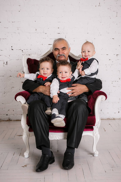 Grandfather with triplets  grandchildren portrait studio shoot - Photo, Image