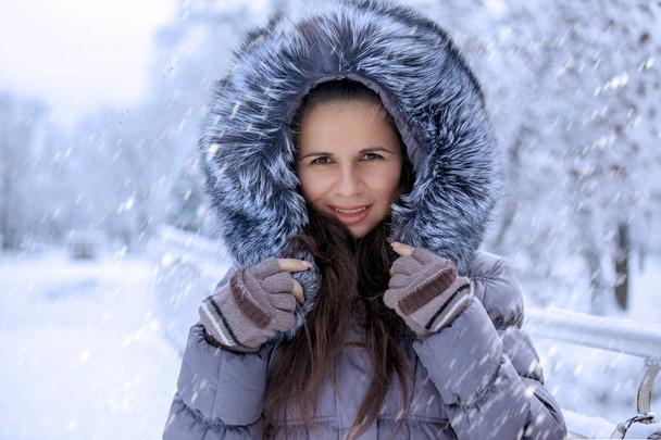 Πορτρέτο μιας γυναίκας όμορφο χειμώνα με γούνινο καπέλο είναι το περπάτημα στο πάρκο - Φωτογραφία, εικόνα