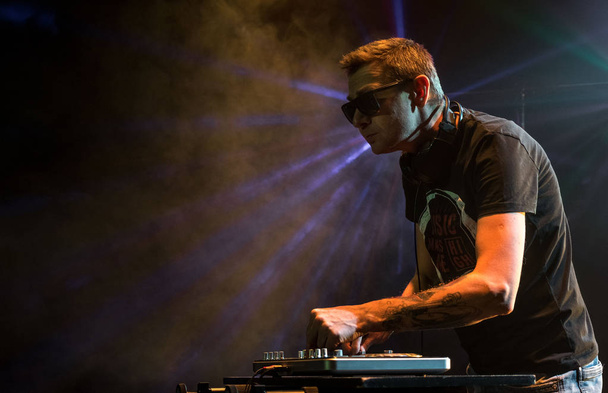 DJ work in a nightclub. Disco light in the club. DJ behind the turntable. - Fotó, kép