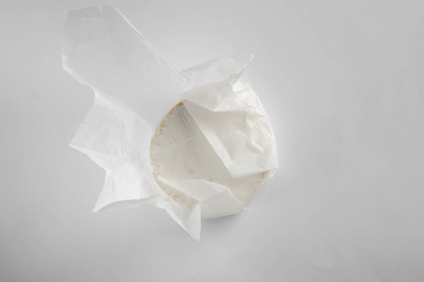 Round cheese camembert or brie on white background. Menu design restaurant. Top view design photo. Cheese in white paper. Overhead - Fotó, kép