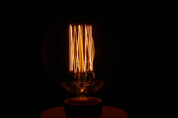 Сяюча вінтажна лампа ізольована на темному фоні
 - Фото, зображення