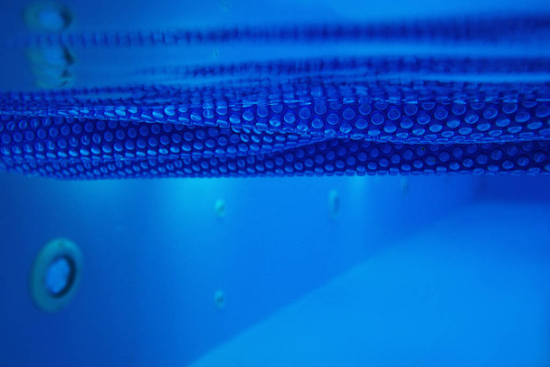 Textur der blauen Solarfolie für das Schwimmbad unter Wasser - Foto, Bild