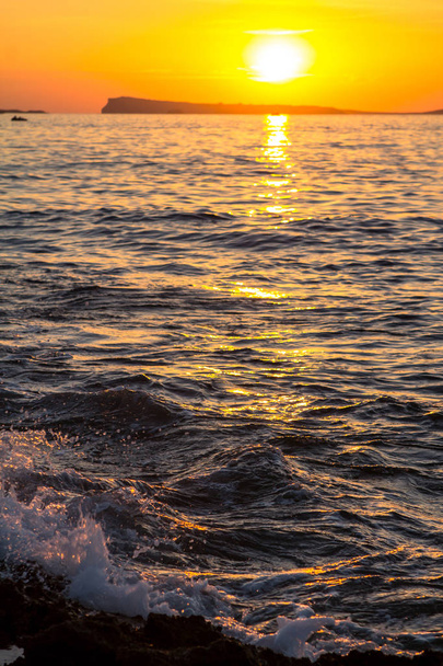 Сплеск води з великої хвилі в морі на заході сонця
 - Фото, зображення