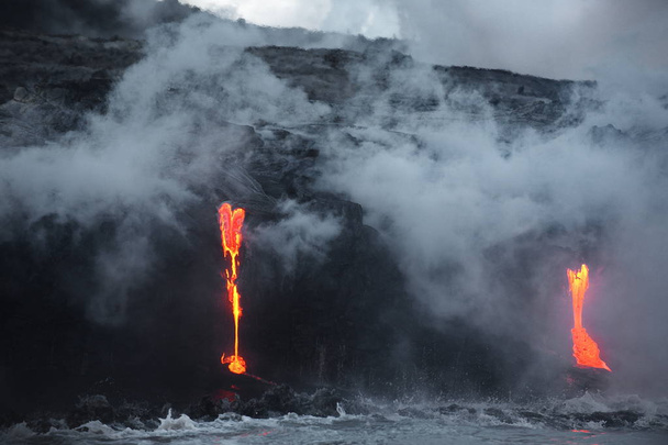 The hot lava of the Hawaiian volcano Kilauea flows into the waters of the Pacific Ocean - Photo, Image