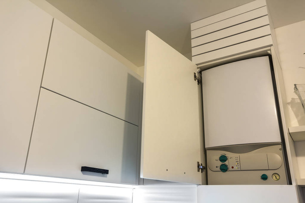 Hausgas-Warmwasserbereiter-Boiler in Küchenmöbeln für die Wohnung der Hausheizung - Foto, Bild