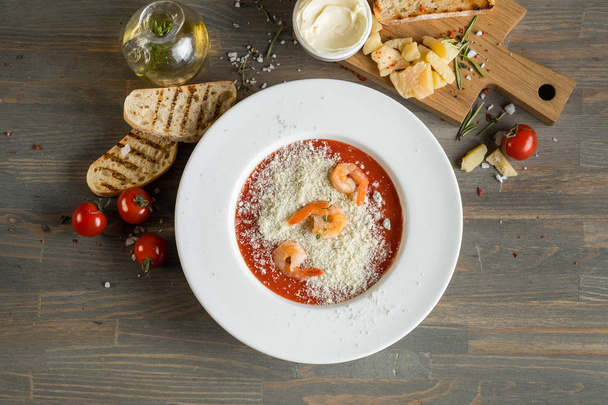 Cream soup with tomato, cheese and other ingredients on the kitchen - Фото, зображення