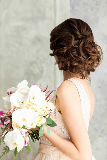 Gorgeous young woman in elegant dress holding bouquet - Photo, image