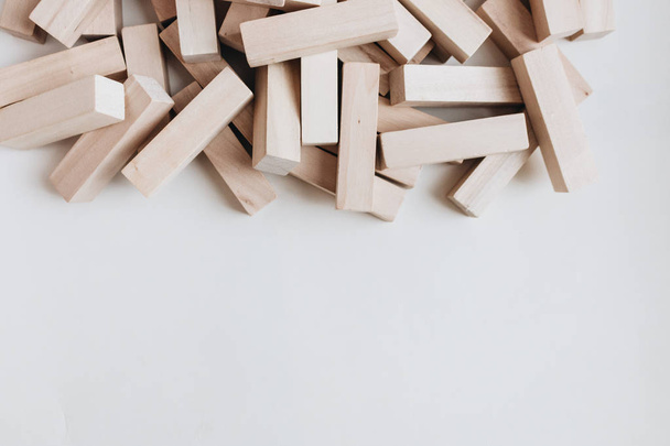 Куча маленьких деревянных блоков для игры в Jenga стол на белом фоне
 - Фото, изображение