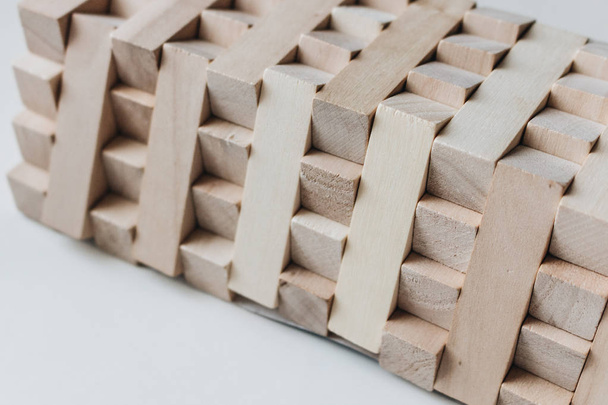 bouw van kleine houten blokken voor de tabel van Jenga spel, witte achtergrond - Foto, afbeelding