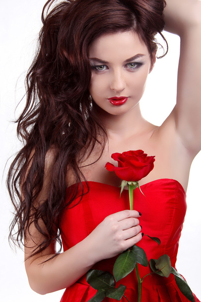 Portrait of beautiful brunette woman holding red rose - Fotografie, Obrázek