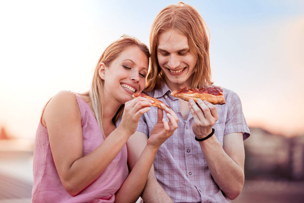 Pareja comiendo pizza snack al aire libre
 - Foto, imagen