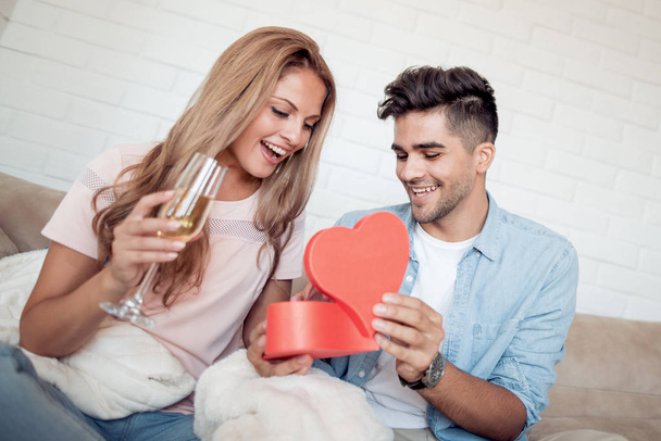 Young man gives his girlfriend a heart-shaped box. - Photo, Image