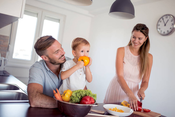 Ευτυχισμένη οικογένεια προετοιμασία λαχανικών μαζί στο σπίτι στην κουζίνα. - Φωτογραφία, εικόνα