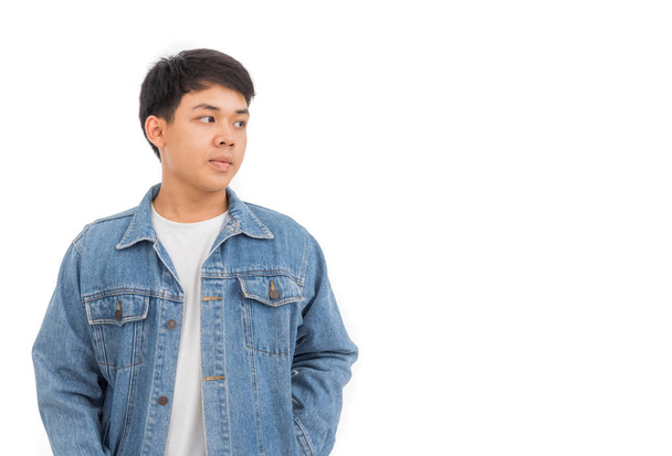 An Asian boy with black hair puts on in studio with white shirt and jeans jacket. - Foto, afbeelding