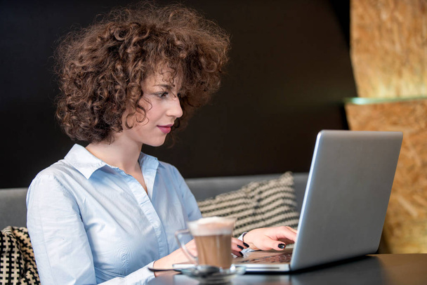 Girl using laptop at a caffe - Фото, зображення