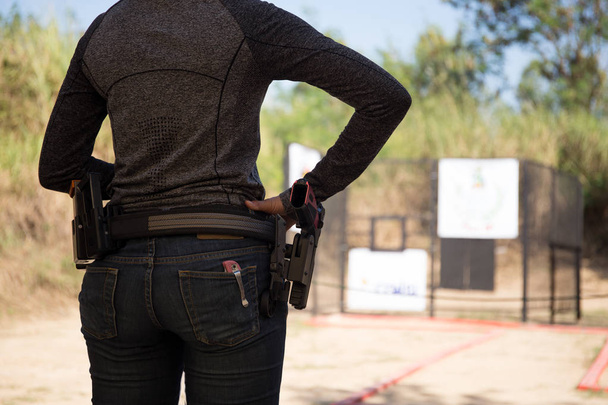Vrouw voeren pistool in zijn tailleband  - Foto, afbeelding