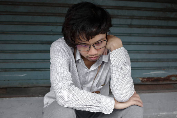 Frustrado estresado joven asiático hombre de negocios sentirse decepcionado o agotado con el trabajo en la oficina exterior
. - Foto, Imagen