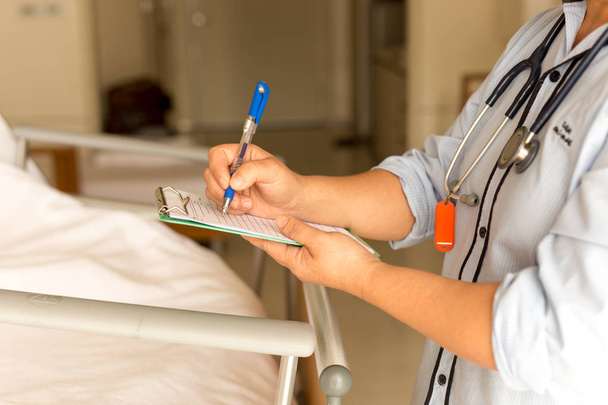 Mulher médico escrever detalhes médicos do paciente
  - Foto, Imagem
