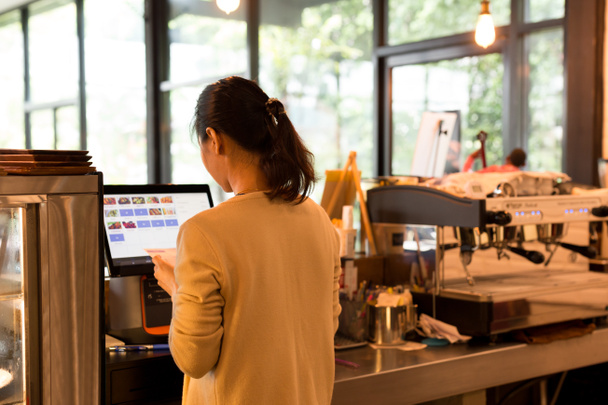 Жінка в касі приймає замовлення і рахунки, використовуючи сучасні с
 - Фото, зображення