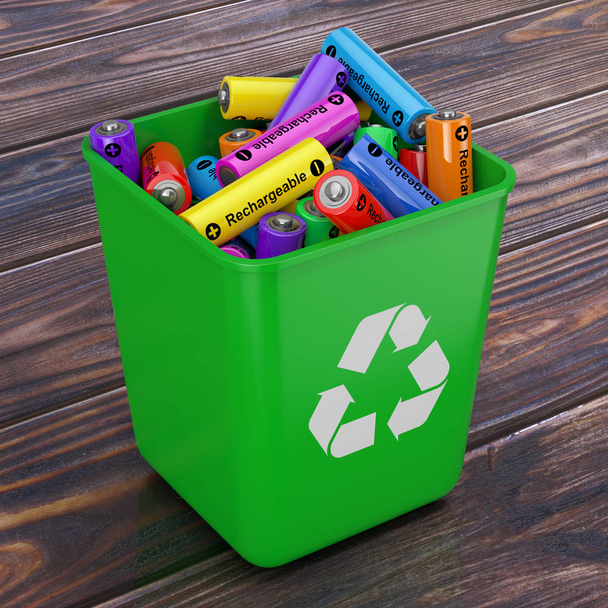 Куча аккумуляторных батарей в зеленом ведре со знаком "Recycle"
 - Фото, изображение