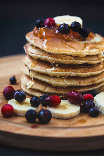 Pancakes with honey, bananas, jam and berries Menu , restaurant recipe concept. Served in - Фото, зображення