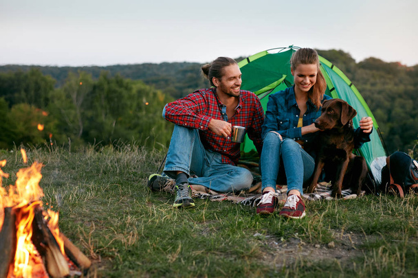 Uomo e donna in viaggio con cane al campo
 - Foto, immagini