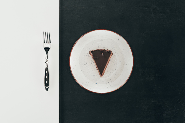 top view of piece of cake on plate and fork - Foto, afbeelding