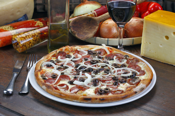 Pepperoni pizza with melted cheese and black olives - Foto, afbeelding