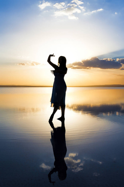 Tanssii veden päällä auringonlaskun aikaan
 - Valokuva, kuva