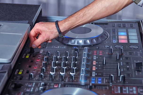 equipamento de música profissional para tocar e controlar música em discoteca com as mãos DJ. Dj mistura a faixa na boate na festa. Auscultadores em primeiro plano e mãos DJ em movimento
 - Foto, Imagem
