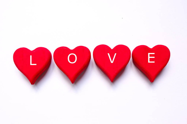 Pohled shora symbol srdce červené dřevěné řemeslníci napsal s "Láskou" na bílém pozadí. Motiv Valentýn. - Fotografie, Obrázek