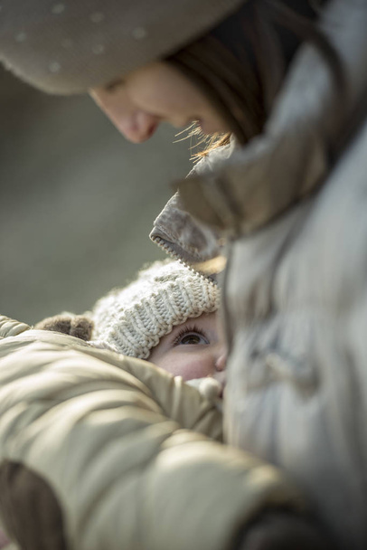 Mujer amamantando a un niño pequeño usando ropa de invierno
 - Foto, Imagen