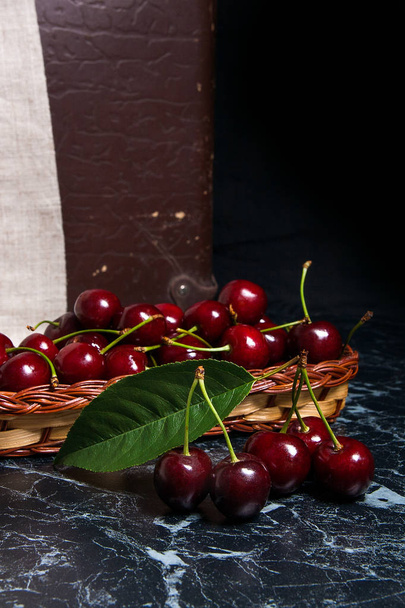 Several red sweet cherries and big green leaf on the table. Fres - Fotó, kép
