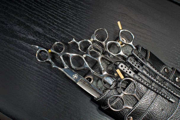 A leather bag of a hairdresser with scissors. Black and white - Photo, Image