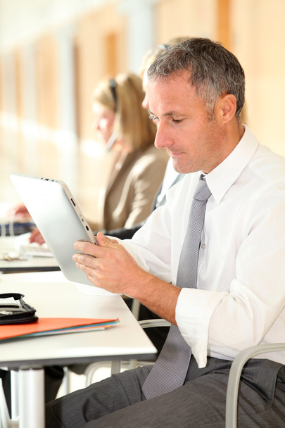 Office worker looking at internet on electronic pad - Φωτογραφία, εικόνα