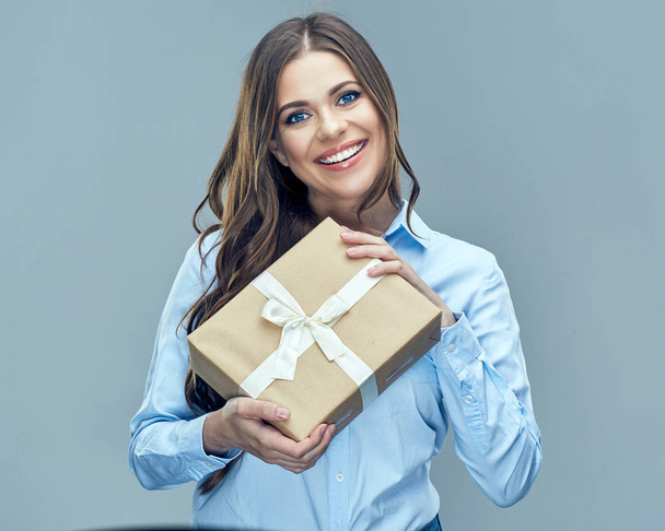Happy businesswoman in shirt holding paper gift box with white ribbon  - Фото, изображение