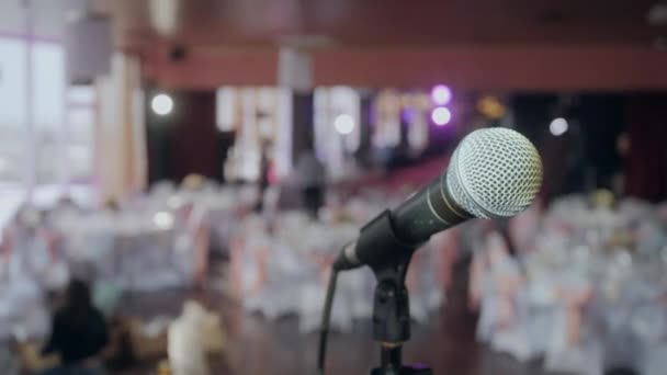 Mikrofonu přes abstraktní rozmazané pozadí konference sál nebo svatební hostinu - Záběry, video