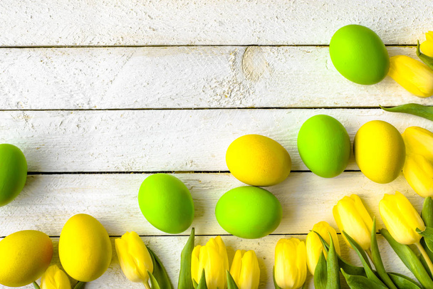 Feliz Pascua huevos y tulipanes en la mesa de madera, decoración festiva
 - Foto, Imagen