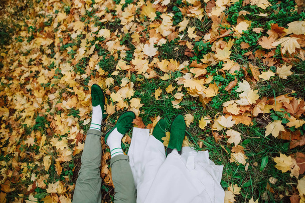boy and girl lie autumn green shoes - Photo, image