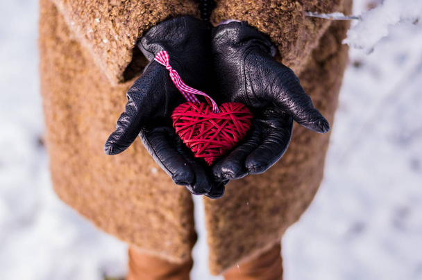 Ahşap bir kırmızı kalp tutan kız - Fotoğraf, Görsel
