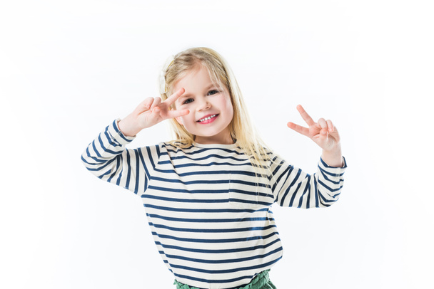 smiling little child dancing and making peace gestures with hands isolated on white - Fotografie, Obrázek