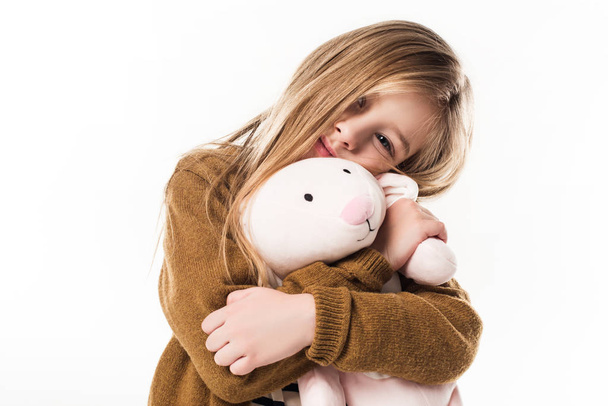 hermoso pequeño niño abrazando con suave juguete conejito aislado en blanco
 - Foto, imagen