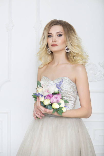 Young pretty bride with bridal bouquet indoors - Photo, Image